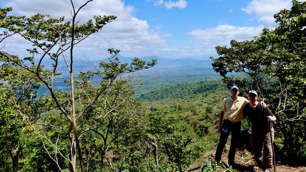 Alejandro Martinez and OCR Green Buyer Roland Glew at Finca Argentina in El Salvador with the Apaneca-Ilamtepec mountain range in the distance