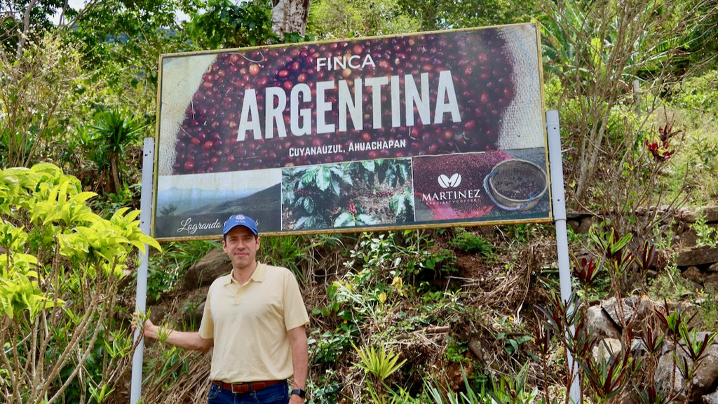 Alejandro Martinez standing proudly with his new signage at Finca Argentina in El Salvador