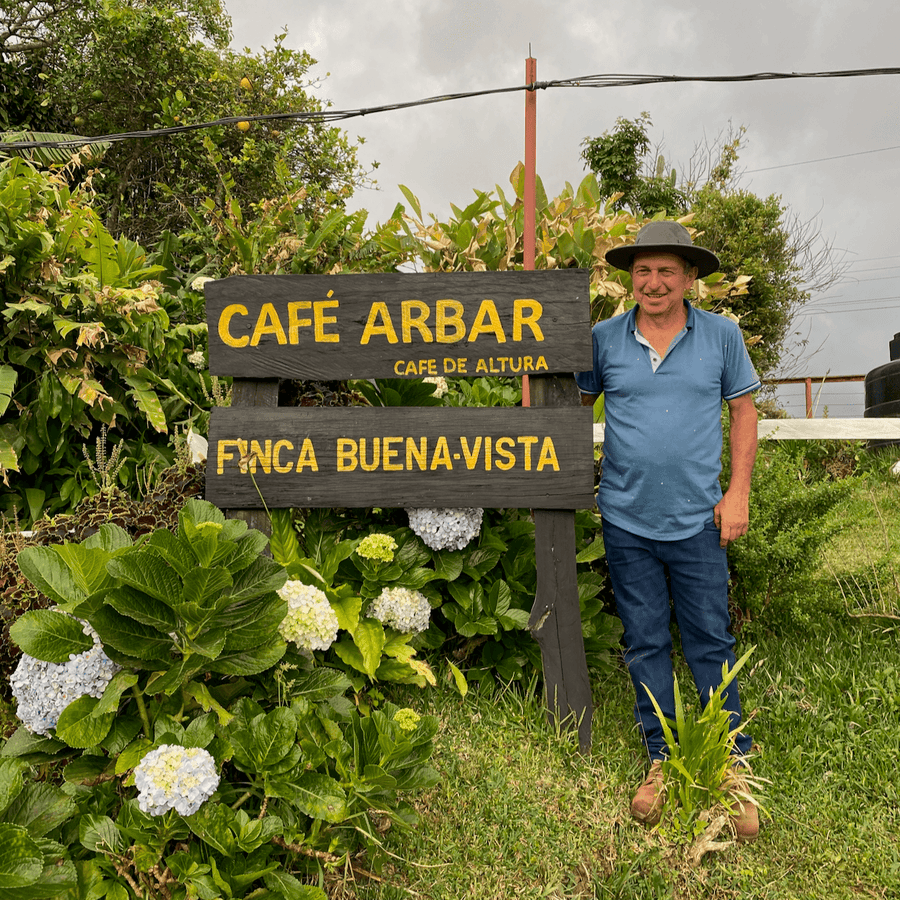 Carlos Arrieta standing beside Café Arbar sign, origin of Costa Rica: Arbar, El Manantial coffee.