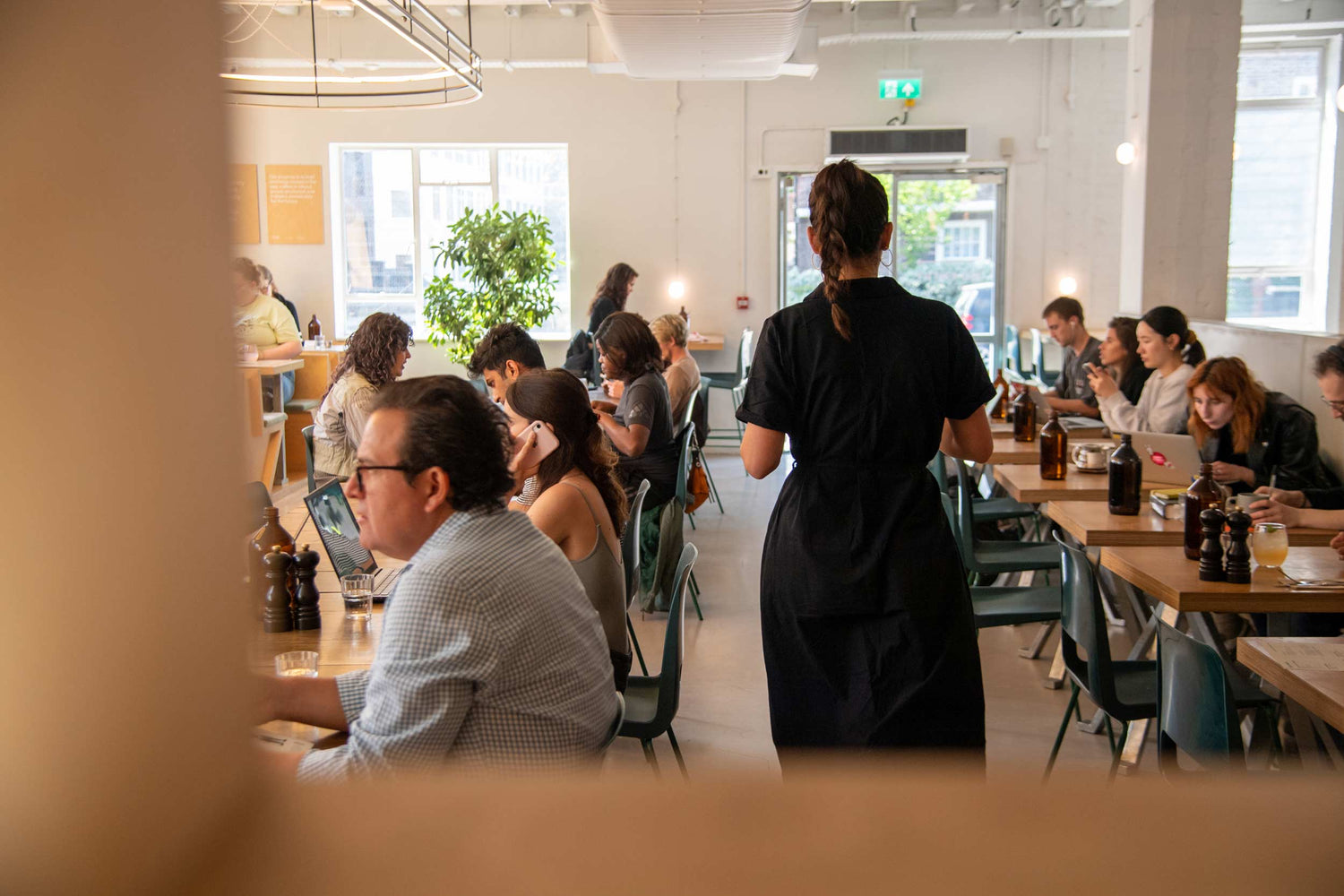 Ozone Coffee Roasters London Fields – bright café interior with wooden tables, green chairs, natural light, and relaxed atmosphere.