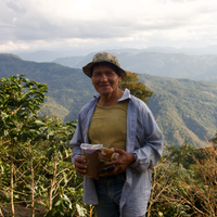 Pedro Flores with a sample of his coffee, stood on his farm Villa Rosario, in Caranavi, Bolivia