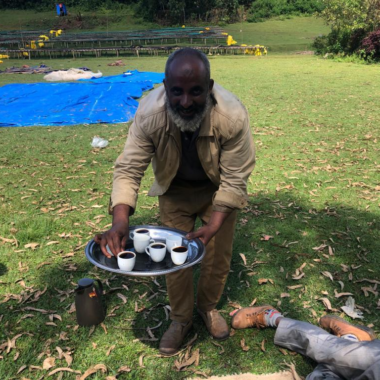 Mensur Aba Hika serving coffee to friends and fellow members of the Tokuma Farmers Group in Jimma, Ethiopia