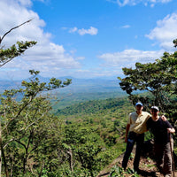 Alejandro Martinez and Ozone Green Buyer Roland Glew at Finca Argentina in El Salvador with the Apaneca-Ilamtepec mountain range in the distance