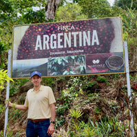 Alejandro Martinez standing proudly with his new signage at Finca Argentina in Ahuachapán, El Salvador