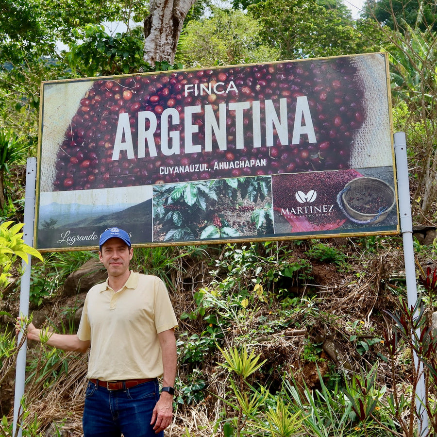 Alejandro Martinez standing proudly with his new signage at Finca Argentina in Ahuachapán, El Salvador