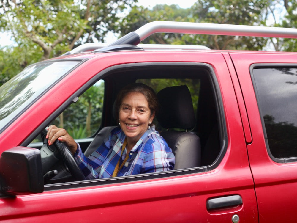 Gloria Rodriguez in her red pickup truck arriving at Finca San José in Ahuachapán, 